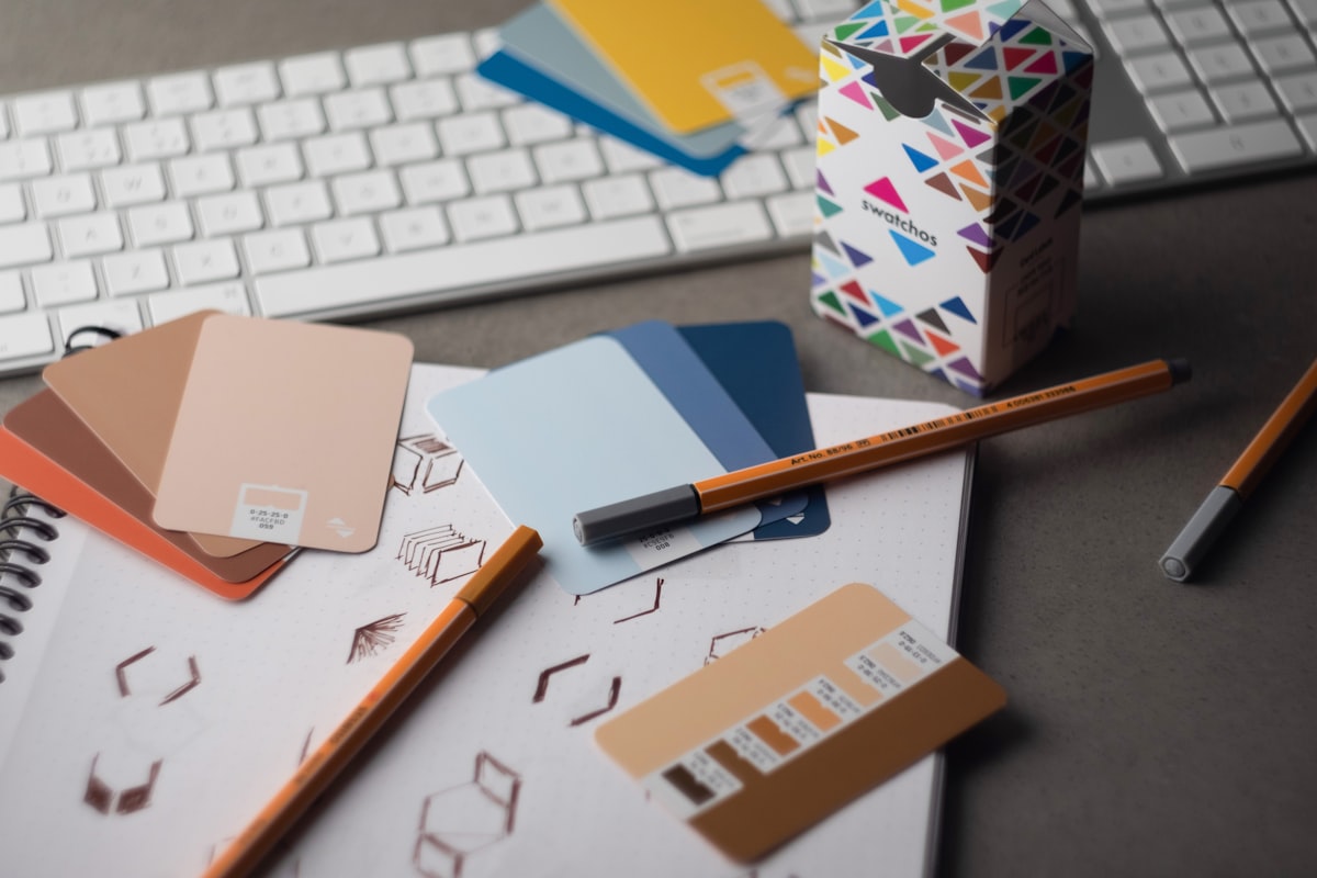 Sampel warna brand yang tertata di atas meja kayu, merepresentasikan pentingnya dokumentasi color palette yang presisi