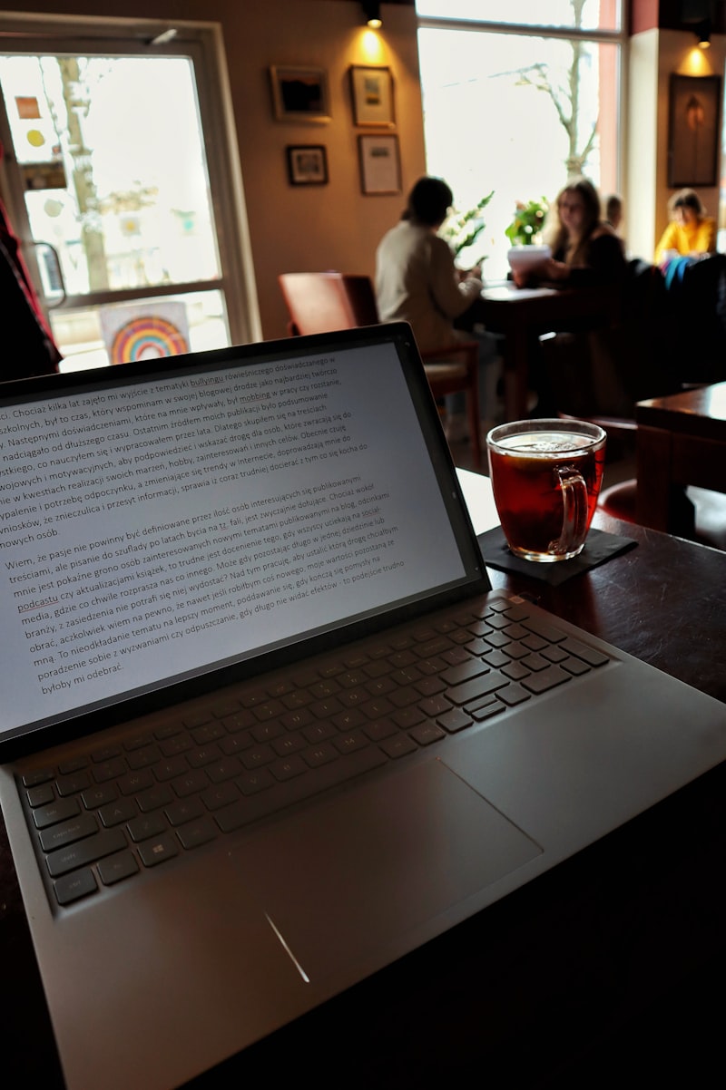 Seseorang sedang menulis blog di kafe, mengedit dan mereview konten sebelum publish