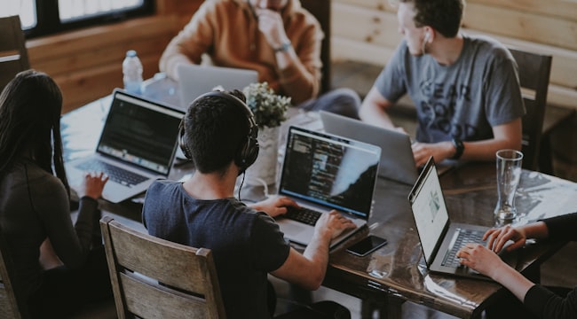 Tim bekerja bersama di depan laptop untuk monitoring pasca-migrasi website