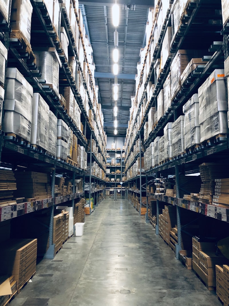 Pekerja gudang memindai barcode pada kotak barang menggunakan scanner untuk sistem inventaris digital
