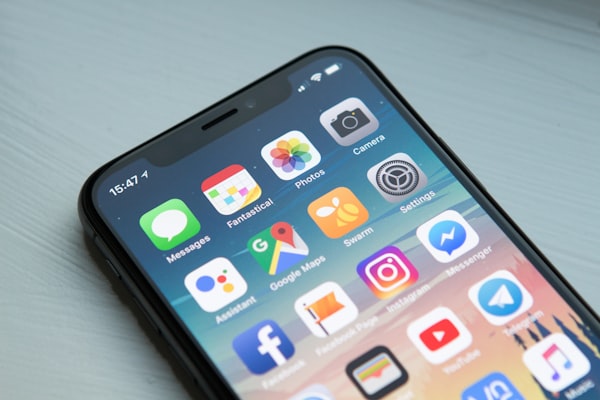 Mockup aplikasi mobile di smartphone modern menampilkan berbagai UI yang dikembangkan dengan framework cross-platform